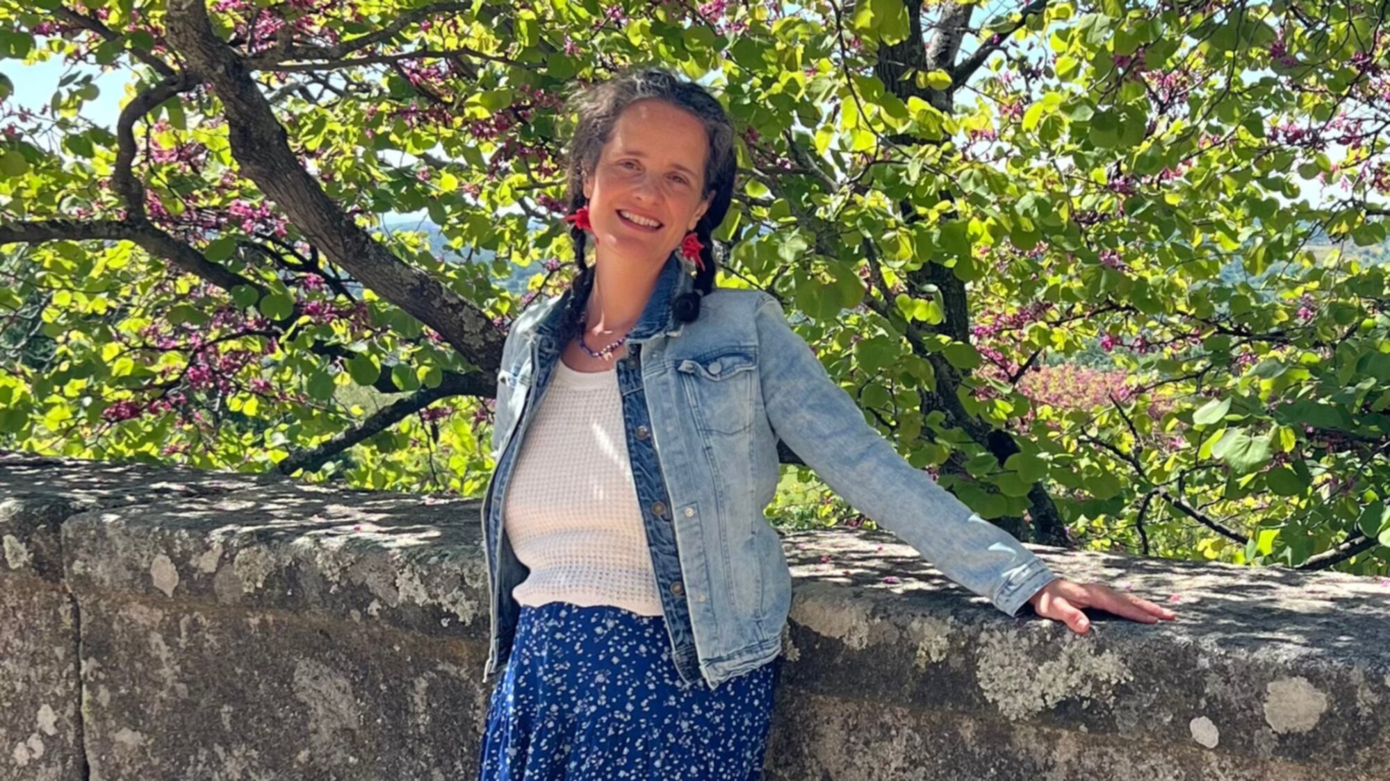 María Nora bajo un árbol de Judas en flor