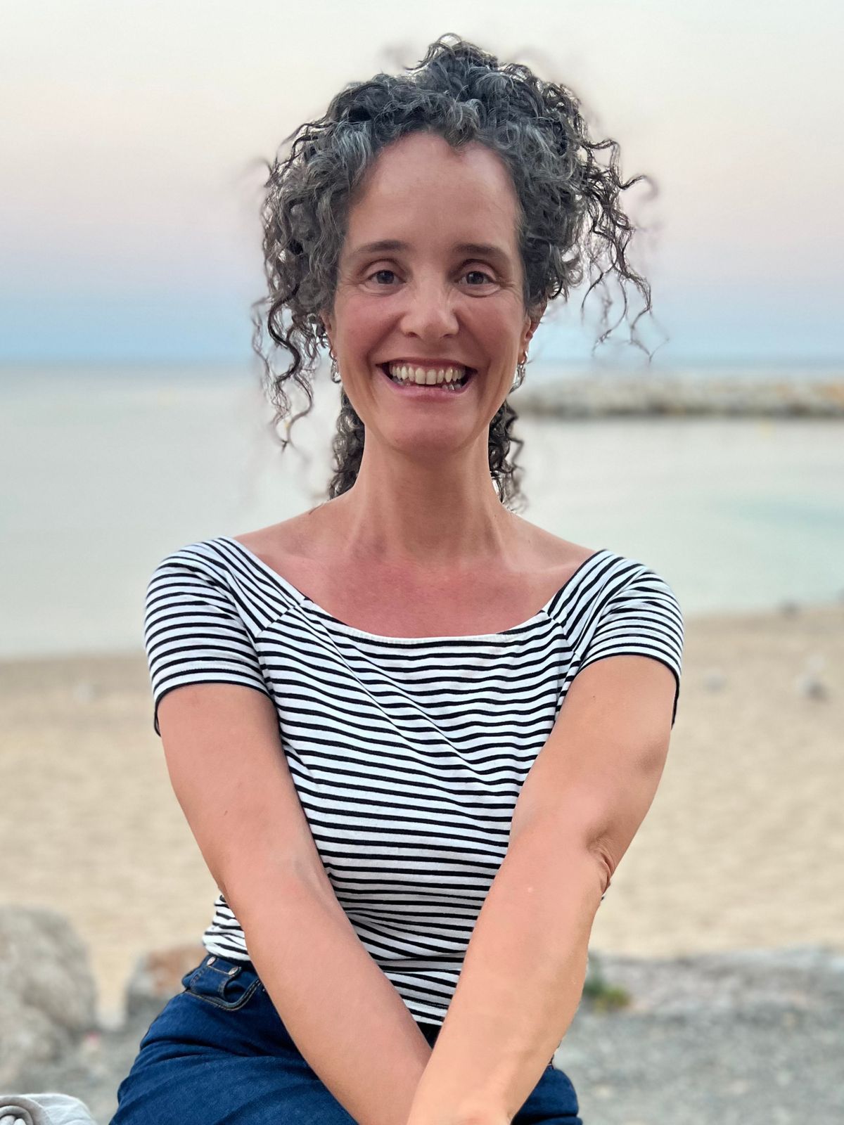 María Nora sonriendo junto al mar